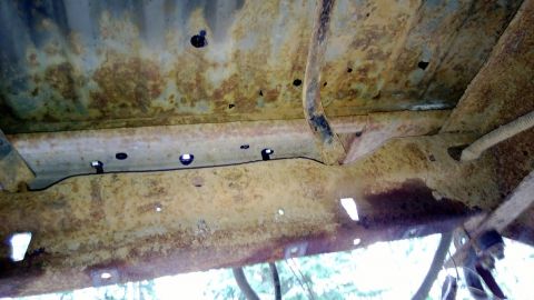 1983 Ford Bronco - Undercarriage of a vehicle showing significant rust and corrosion on the frame components.