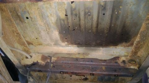 1983 Ford Bronco - The undercarriage of this vehicle shows extensive rust and corrosion, with numerous holes visible in the metal.