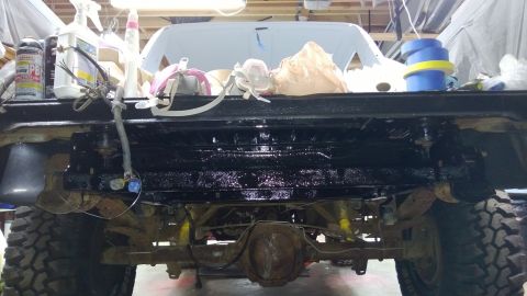 1983 Ford Bronco - The rear axle and frame of a Ford Bronco are visible as it undergoes maintenance or restoration work.