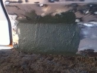 1996 Ford Bronco - Body filler applied to a damaged rocker panel during vehicle repair.