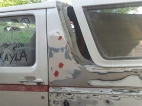 1996 Ford Bronco - Bodywork in progress on a 1996 Ford Bronco, showing primer and a red stripe detail.