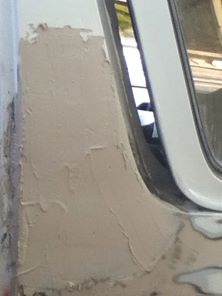1996 Ford Bronco - Bodywork in progress on a vehicle, showing a section of filler applied to the rear quarter panel.