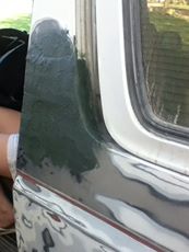 1996 Ford Bronco - Detail of a vehicle door panel showing wear and tear on the paint and trim.