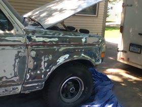 1996 Ford Bronco - This Ford Bronco is in the process of being repaired, with its hood up and bodywork visible on the fender.