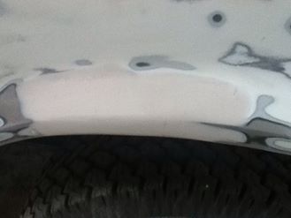 1996 Ford Bronco - This image shows a section of a vehicle's body undergoing repair, with visible filler and a tire.