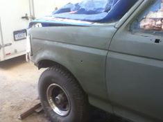 1996 Ford Bronco - 1996 Ford Bronco undergoing bodywork, showing primer gray paint on the fender and wheel well.