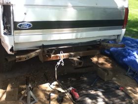 1996 Ford Bronco - Rear view of a white Ford Bronco, showing the tow hitch and SuperMotors branding.