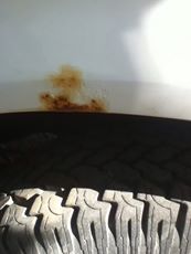 1996 Ford Bronco - Close-up of a tire and fender area with visible text and rust.