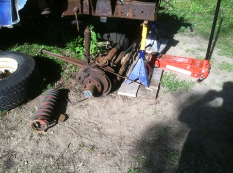 1989 Ford Bronco - Vehicle suspension components are disassembled and staged for repair or replacement outdoors.