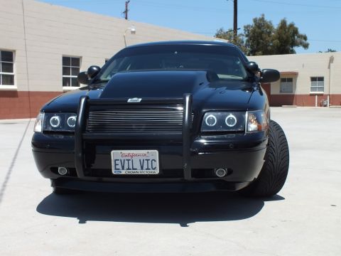 2003 Ford Crown Victoria - Head-on view of a black Ford Crown Victoria with halo lights, push bar and an EVIL VIC plate framed Crown Victoria.