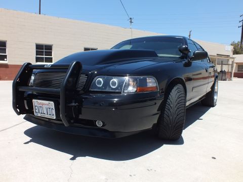 2003 Ford Crown Victoria - Low-angle front quarter of a black Ford Crown Victoria with halo headlights, push bar and an EVIL VIC plate.