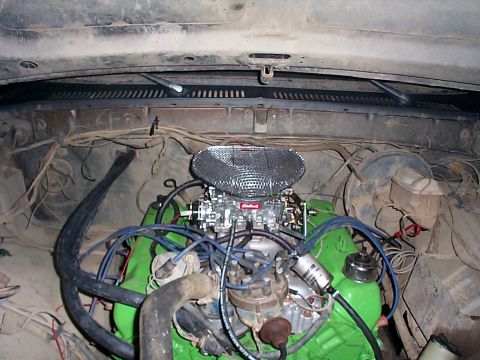 1979 Ford Bronco - The engine bay shows a green engine block with a chrome air cleaner and carburetor, surrounded by various hoses and wires.