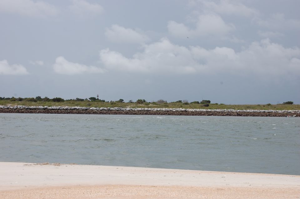 Water and beach scene with a distant lighthouse and a "SUPERMOTORS" logo