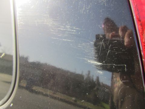 2003 Honda CR-V - A black car door exhibits extensive scratching, obscuring any identifying details.