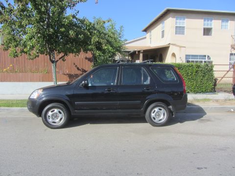 2003 Honda CR-V - A black SUV is parked on the side of a residential street with a house in the background.