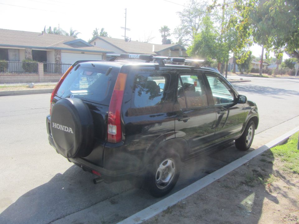 2003 Honda CR-V parked on street, rear view with spare tire cover