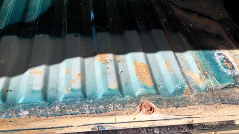 1996 Ford Bronco - Close-up view of a weathered truck bed interior, showing corrugated metal and areas of rust.