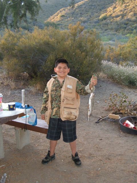 1988 Ford Bronco - A young angler proudly displays his catch of the day in an outdoor setting.