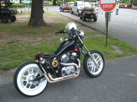 1972 Ford Ranchero - Custom motorcycle parked on asphalt with grass and trees in the background.
