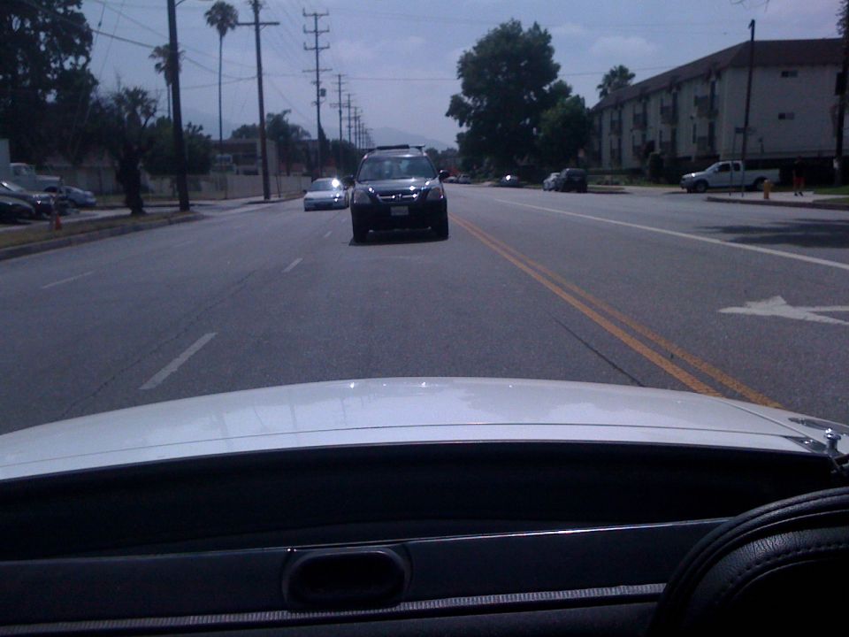 Black SUV driving on a road, seen from inside another vehicle
