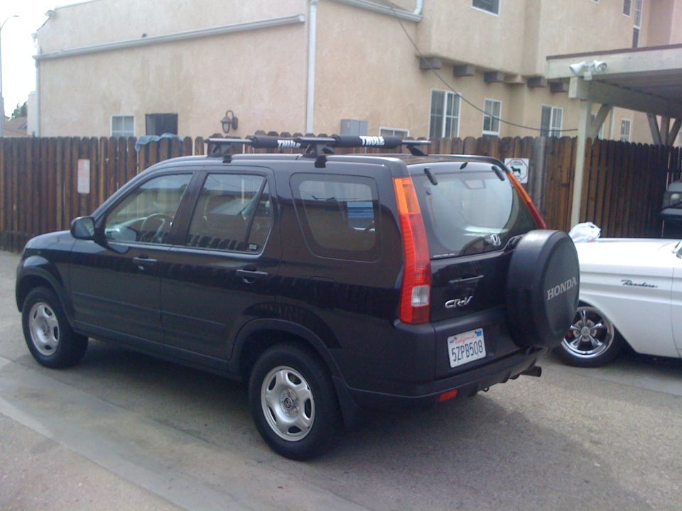 Black Honda CR-V, rear view, with roof rack and spare tire. License plate 5ZPB508