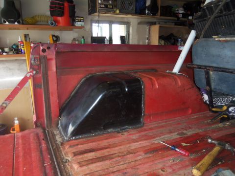 1968 Ford Bronco - The interior of a truck bed shows a newly installed black fuel tank cover over the rear wheel well.