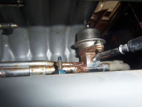 1968 Ford Bronco - Close-up view of a fuel pressure regulator, showing its metallic parts and connections.