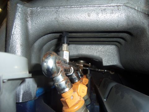 1968 Ford Bronco - Close-up view of an engine's intake manifold, showing fuel injectors and a sensor attached.