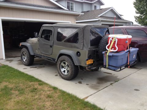 2005 Jeep Wrangler - A Jeep Wrangler is parked in a driveway with a hitch hauler loaded with a cooler and storage bin.