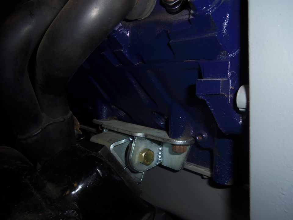 Blue engine block with metal bracket and black exhaust pipes