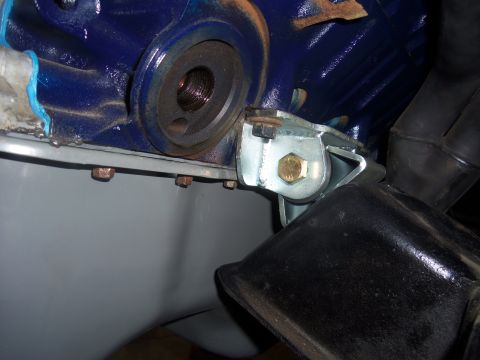1968 Ford Bronco - Close-up view of an engine mount bracket attached to a blue engine block, with visible bolts and metal components.