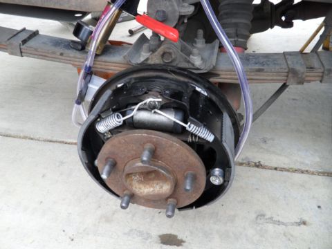 1994 Jeep Cherokee - Close-up of a vehicle's rear drum brake assembly, showing internal components and brake bleeding tubes.