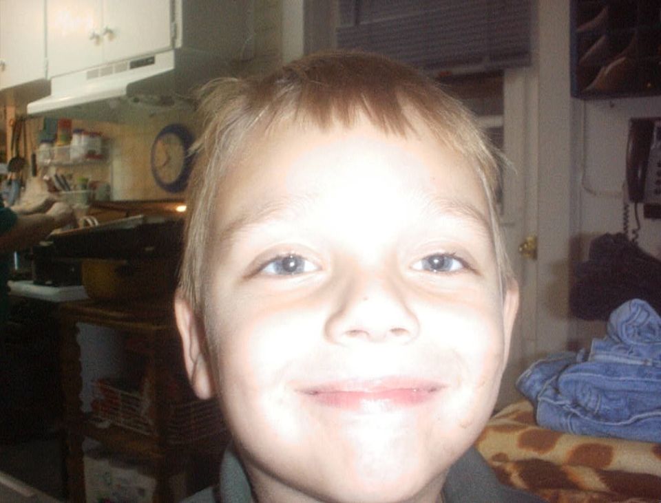 Child smiling in a kitchen, Supermotors logo visible