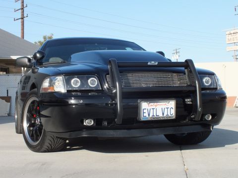 2003 Ford Crown Victoria - Low front angle of a black Ford Crown Victoria with billet grille, halo lights, push bar, and EVIL VIC California plate.