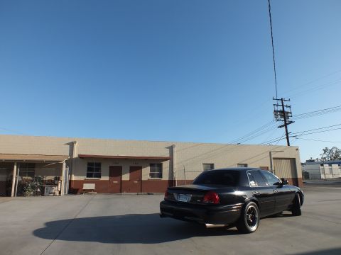2003 Ford Crown Victoria - black Ford Crown Victoria parked in a large industrial lot, viewed from the rear quarter under a clear blue sky.
