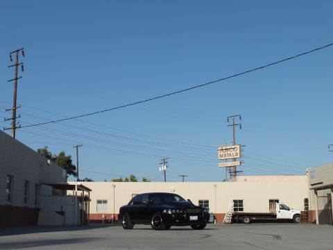 2003 Ford Crown Victoria - black Ford Crown Victoria parked in an industrial yard near an ASCO Metals sign and a white flatbed truck.