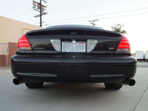 2003 Ford Crown Victoria - rear of a black Ford Crown Victoria shows the Ford oval, an STT badge, dual exhaust and the EVIL VIC California plate.
