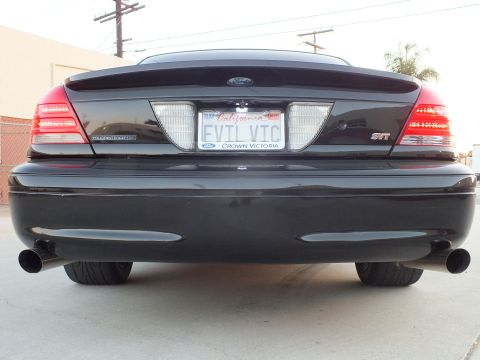 2003 Ford Crown Victoria - Tight rear shot of a black sedan showing dual exhaust, an EVIL VIC plate and a Crown Victoria plate frame.