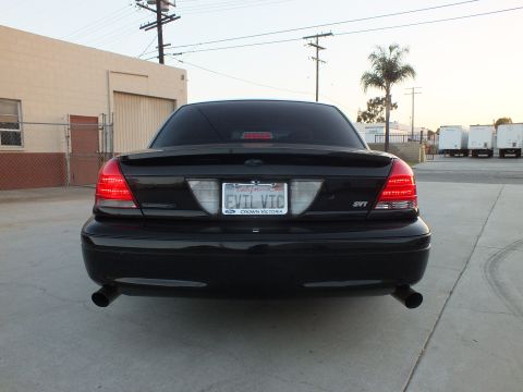2003 Ford Crown Victoria - Rear view of a black full-size sedan with round dual exhaust tips, an EVIL VIC plate and a Crown Victoria frame.
