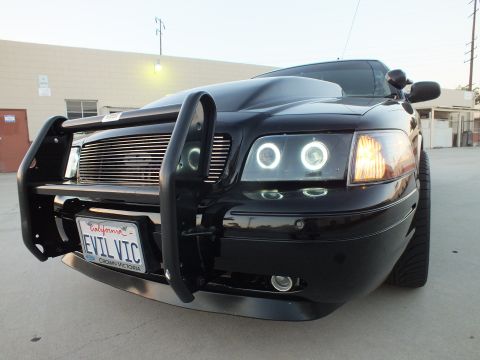 2003 Ford Crown Victoria - black Ford Crown Victoria front end with billet grille, halo headlights and a push guard, wearing California plate EVIL VIC.