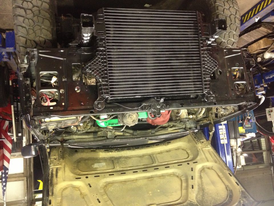 Underside view of a vehicle with a large radiator installed. Some engine parts are visible