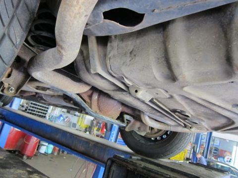 1991 Ford LTD Crown Victoria - Underside view of a vehicle, revealing exhaust pipes, fuel tank, and suspension parts.