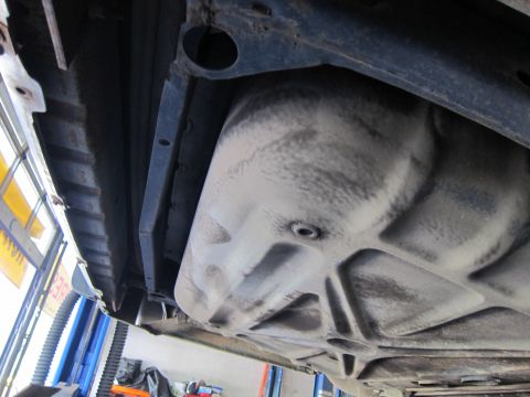 1991 Ford LTD Crown Victoria - The underside of a vehicle, likely in a repair shop, shows the fuel tank and structural components.