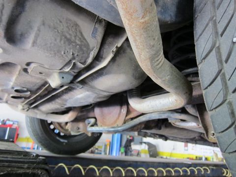 1991 Ford LTD Crown Victoria - A close-up view of the undercarriage of a vehicle, revealing its mechanical components and a tire.