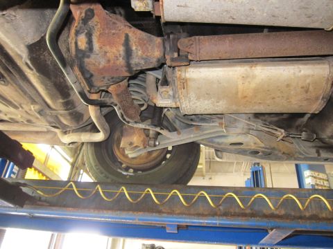 1991 Ford LTD Crown Victoria - Undercarriage view showing the rear axle, suspension, and exhaust system of a vehicle.