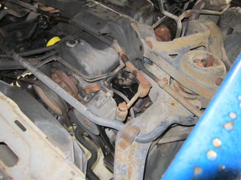 1991 Ford LTD Crown Victoria - Close-up of the engine bay of a 1991 Ford Crown Victoria LTD, showing various mechanical parts and suspension elements.