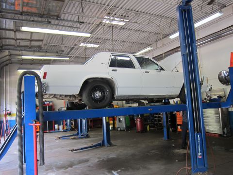 1991 Ford LTD Crown Victoria - A white 1991 Ford Crown Victoria LTD is shown on a car lift in a service bay.