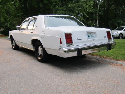 1991 Ford LTD Crown Victoria - Rear view of a white Ford Crown Victoria sedan, likely from the late 1980s or early 1990s.