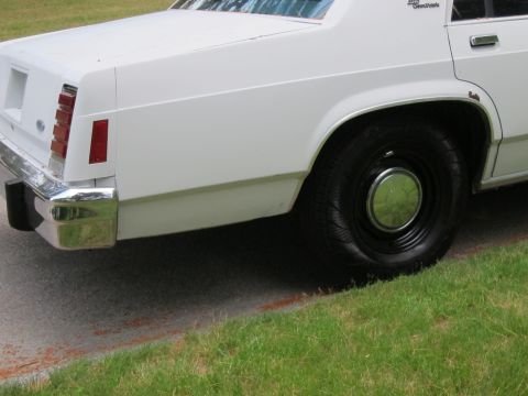 1991 Ford LTD Crown Victoria - Rear view of a white 1991 Ford Crown Victoria LTD showing the quarter panel and wheel.
