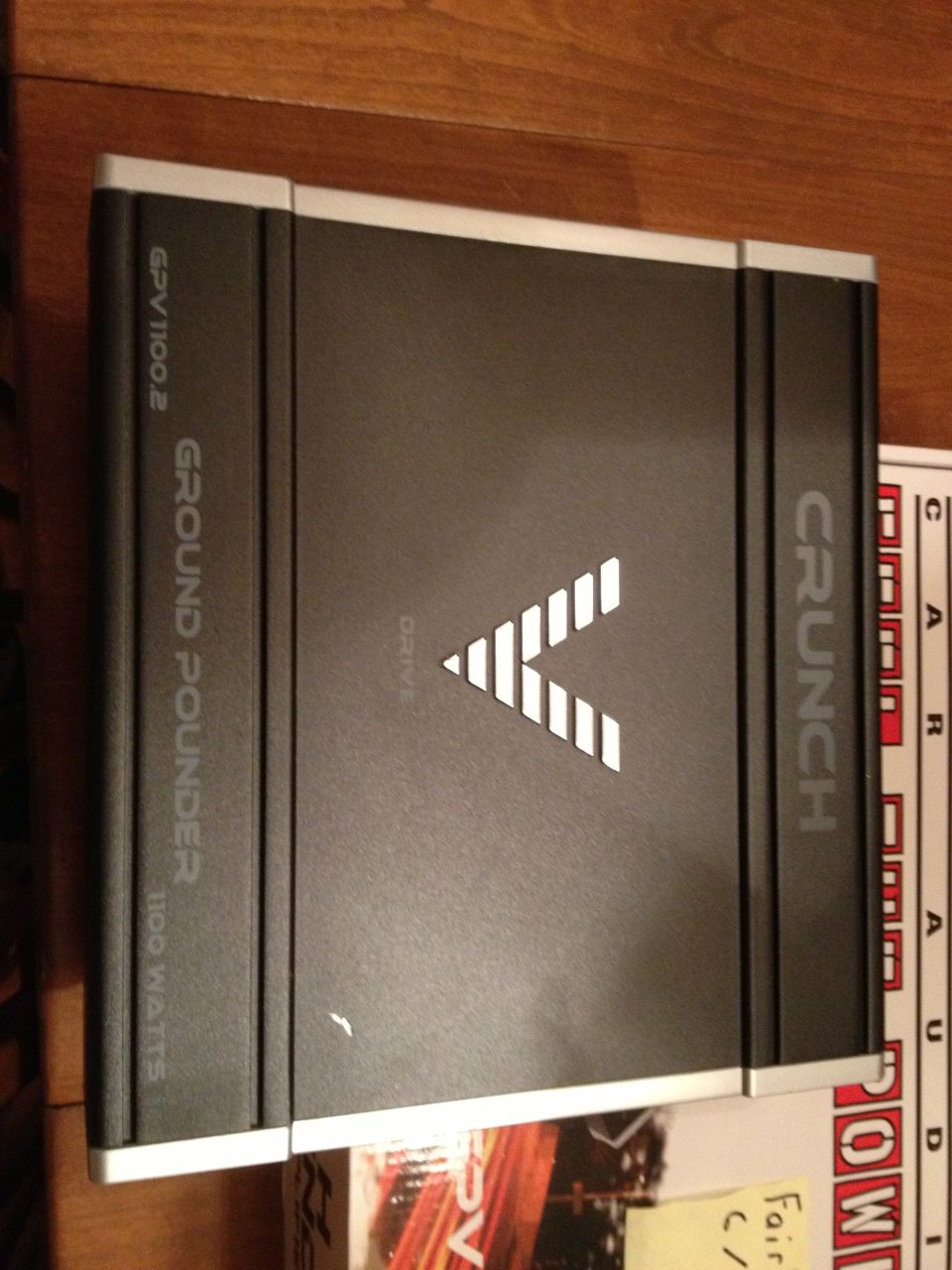 Black car amplifier with white V logo and text 'CRUNCH' and 'GROUND POUNDER 1100 WATTS'